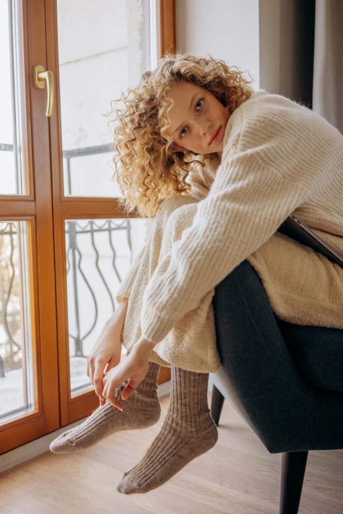 Blonde Frau mit Naturlocken vor einem Balkon, Curly Girl Methode