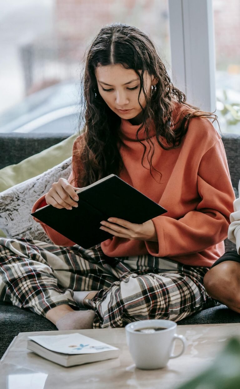 Frau mit Naturwellen nach Wavy Hair Methode liest ein Buch in bequemen Klamotten